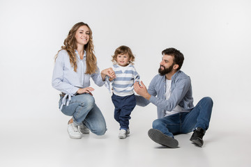 A happy smiling family on white studio background. The father, mother and son posing together