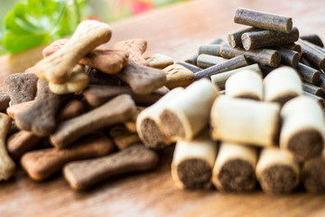 Dog tasty colored biscuits on wooden background, snacks for dogs