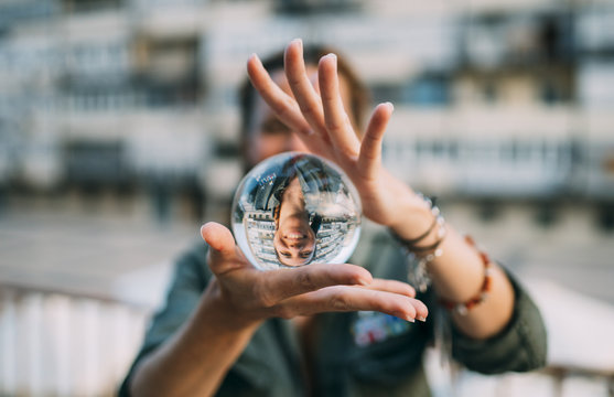 Redhead girl catching a crystal ball. Smile through the ball.