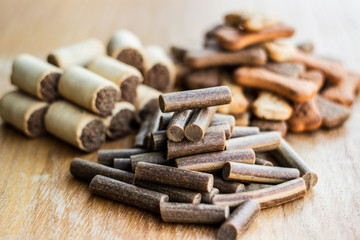 Dog tasty colored biscuits on wooden background, snacks for dogs 