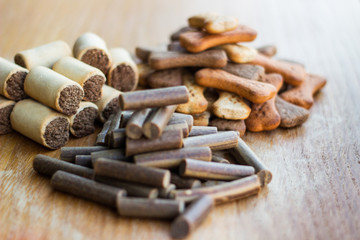 Dog tasty colored biscuits on wooden background, snacks for dogs 