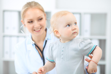 Doctor and patient in hospital. Little girl is being examined by pediatrician with stethoscope. Medicine and health care