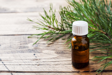 Cedar and spruce essential oil in small glass bottles on wooden background. Selective focus.
