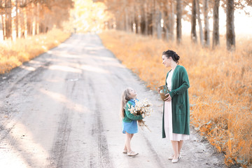 Mother with daughter walking on a road