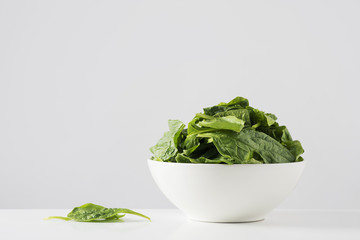 raw spinach leaves in a white bowl