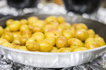 Many small potatoes on silver frying pan