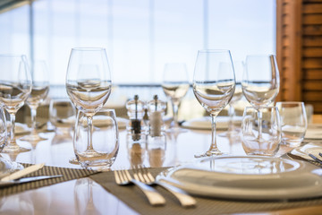 Table with plates, glasses and silverware in an elegant restaurant