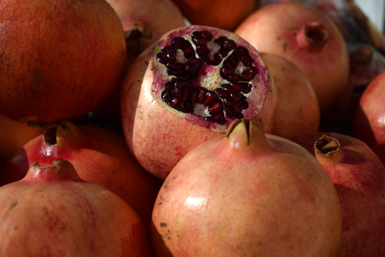 Fresh ripe burgundy pomegranates on the counter market