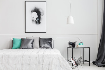Minimalist, framed poster mock-up on a white wall of an artistic bedroom interior with elegant decor and gray textiles - obrazy, fototapety, plakaty