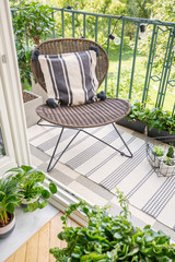 Relax zone on a balcony with a chair, rug and plants. Top view, real photo