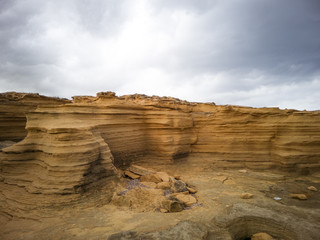 Rocky coast of Mallorca, Spain with limestone rocks of various shapes and dark stormy sky