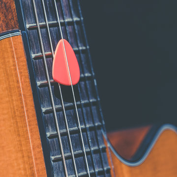 pink pick on guitar neck, music background