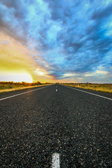 Outback road leading to dramatic sunrise