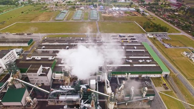 Drone or camera flies into smoke or steam. Aerial view. Smoke comes out of chimney, tube. Emission to atmosphere from industrial pipe. Eco-friendly woodworking factory