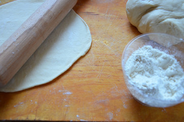 Home autumn, summer baking, puff pastries. Apple strudel with nuts, raisins, cinnamon and powdered sugar. On wooden table. Sliced, with ingredients. Copy space top view. pie ingredients