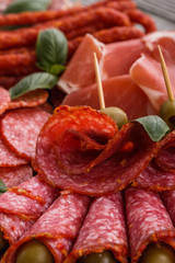 Cold smoked meat plate on a rustic wooden background