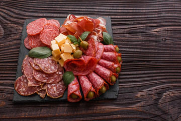 Cold smoked meat plate on a rustic wooden background