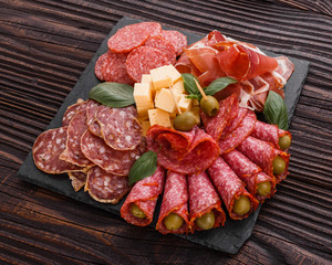 Cold smoked meat plate on a rustic wooden background