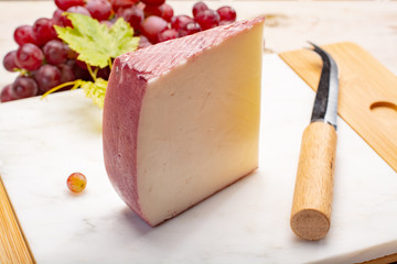 Traditional Spanish cheese, Murcian wine cheese from goat milk with rind washed in red wine, served with fresh ripe grapes