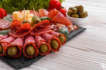 Cold smoked meat plate on a rustic wooden background