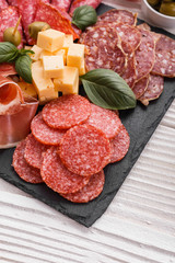 Cold smoked meat plate on a rustic wooden background