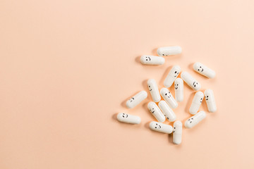 Capsules with painted emotions on a solid background.