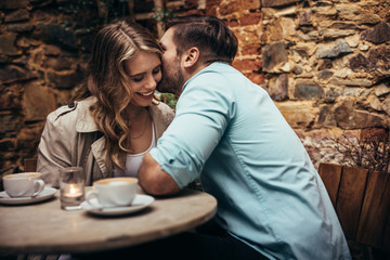 Romantic couple on a date sitting in a restaurant - obrazy, fototapety, plakaty