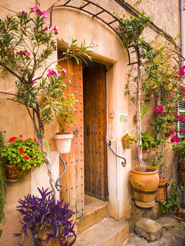 A Typical Mediterranean House With A Front Door Decoration Of Flower Pots With Colorful Plants