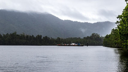 Daintree river ferry crossing against cloud covered mountain