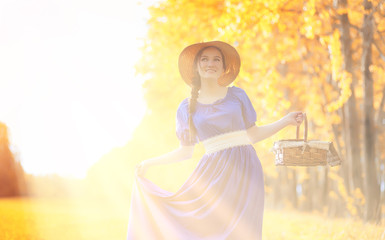 Young beautiful girl in dresses on nature. A girl in a hat walks