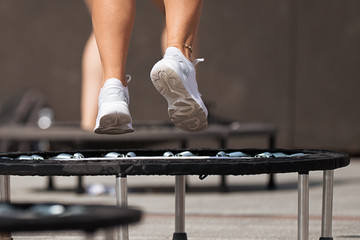 Fitness women jumping on small trampolines,exercise on rebounder - obrazy, fototapety, plakaty