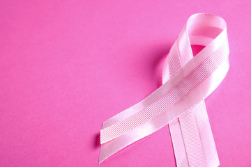 The pink colored ribbon - international symbol of breast cancer awareness and moral support for...