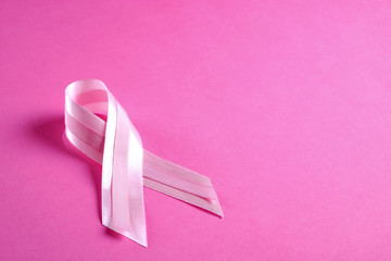 The pink colored ribbon - international symbol of breast cancer awareness and moral support for women. Isolated background, copy space, close up, top view fat lay.