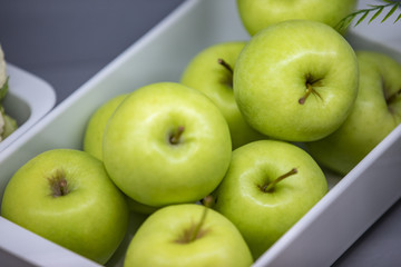 Bowl with fresh green apples on table, closeup