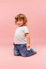Portrait of happy joyful beautiful little boy, studio shot on pink