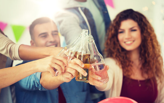 corporate, celebration and holidays concept - happy coworkers clinking bottles with non-alcoholic drinks at office party