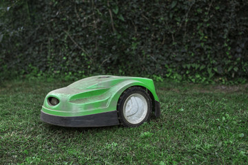 broken robotic lawnmower with a lot of dust in home garden