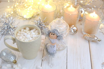 Fototapeta na wymiar Christmas holiday background. Christmas angel, decor, cocoa cup and candles on white wooden table. cozy composition for festive Winter season. Advent time.