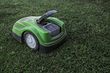 broken robotic lawnmower with a lot of dust in home garden
