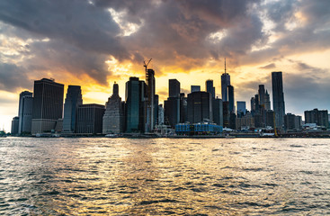 New York City Manhattan midtown panorama at sunset  viewed from Brooklyn Bridge park