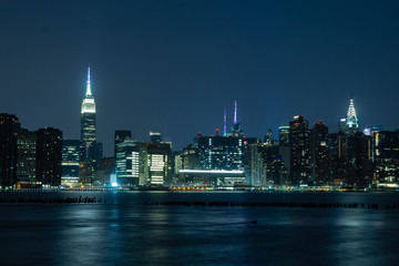 Fototapeta na wymiar Long time exposure of New York City Manhattan midtown skyline at night viewed from Transmitter Park