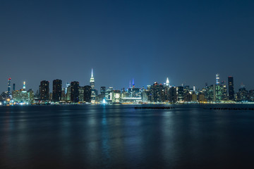 Obraz premium Long time exposure of New York City Manhattan midtown skyline at night viewed from Transmitter Park