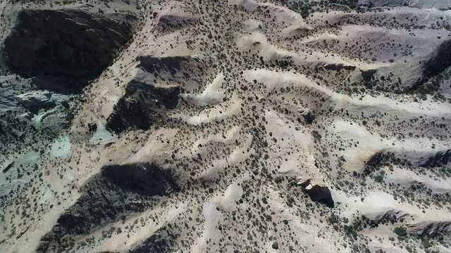 Aerial senital drone scene of colourfull sandy and rocky mountains. Sand dunes with vegetation, eroded landscape in Uspallata, Mendoza, Argentina.