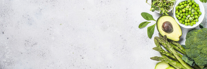 Green food assortment on light stone background. 