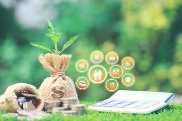 Growing plant on Money bag with stack of coins money and hologram on natural green background, Saving for prepare in future and Business investment concept