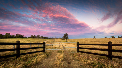 Colourful sunset in rural setting with wooden fence