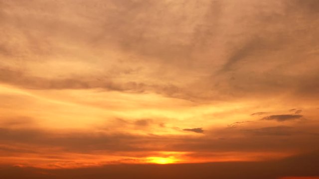 4K orange sunset as the massive sun sets into the horizon above the city