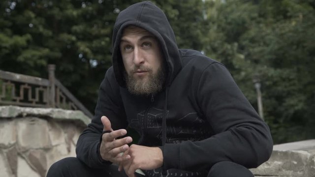 Street gangster scares the passerby at park. 4K