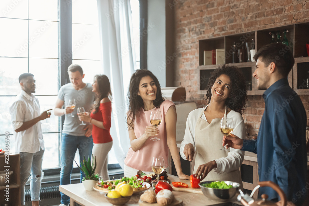 Wall mural Group of happy friends talking and drinking wine