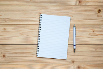 blank notebook with pen on wooden background. top view and copy space for your text